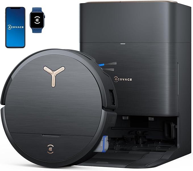 Robô aspirador Ecovacs em versão premium na cor preta, acompanhado de base “tudo-em-um” para limpeza automática, mostrado ao lado de smartphone e smartwatch compatíveis — um dos melhores robôs aspiradores 2026 para automação completa.